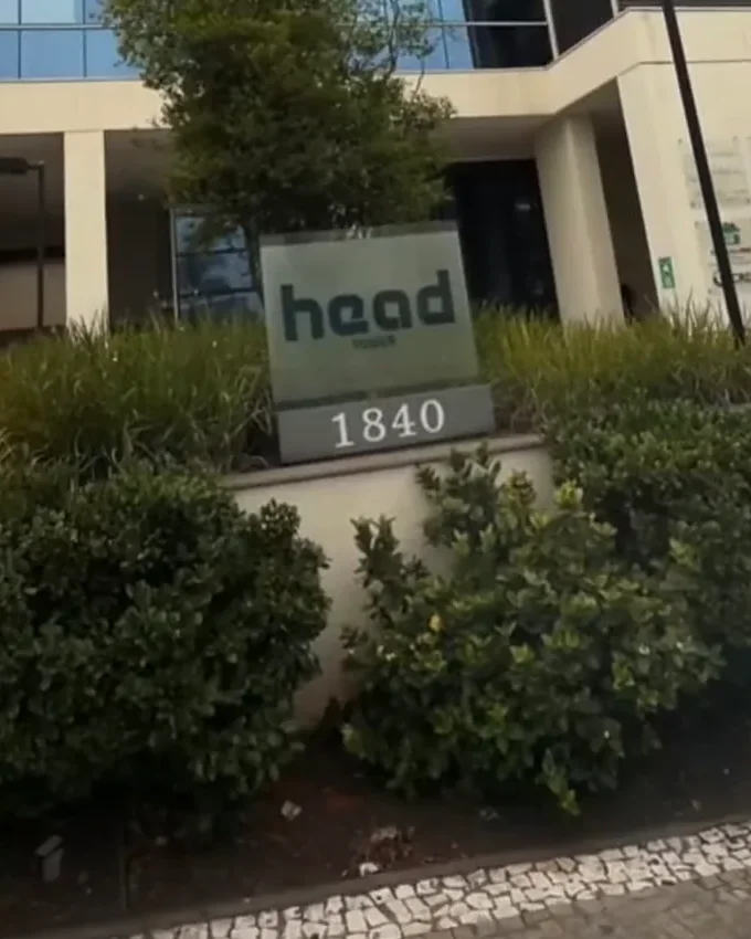 Placa do Edifício Head Tower, número 1840, entre os arbustos da calçada da Av. Independência